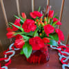 Red tulips and carnations in a red glass vase
