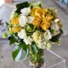 Yellow and white roses arranged in a clear glass vase
