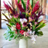 Tropical bouquet in a white vase with pink and white orchids