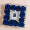 Blue roses arranged in a clear square box with a glittery center