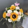 Bouquet of sunflowers, pink roses, and white blooms with a butterfly pick