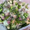Large bouquet of pale pink and white flowers with green accents