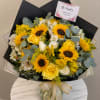Bouquet of yellow sunflowers, yellow and white roses, and white alstroemeria in a glass vase