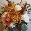 Autumn bouquet with orange chrysanthemums, white roses, and an orchid in a wooden box