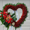 An open heart sympathy arrangement filled with burgundy chrysanthemums. A side accent