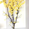Tall yellow flowering tree arrangement in a moss-covered base