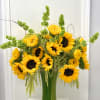 A vibrant, joyful arrangement overflowing with sunny yellow sunflowers, lush green foliage