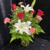 Bouquet of red roses, white lilies, and pink carnations in a glass vase