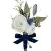 White boutonniere with blue accent flower and navy ribbon bow