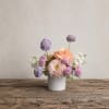 Small pastel flower arrangement in a white vase