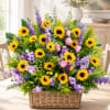 Basket arrangement of sunflowers, pink roses, and purple flowers
