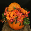 Orange flowers arranged in a pumpkin centerpiece