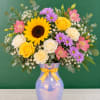 Mixed bouquet in a lavender vase with a yellow ribbon
