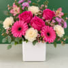 Pink roses and gerbera daisies in a white vase