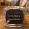 Chocolate fudge in a clear plastic container with a label