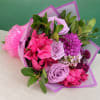 Bouquet of pink and lavender flowers wrapped in purple paper