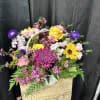 Mixed flower basket with yellow roses, sunflowers, and purple blooms