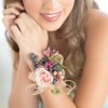 Woman wearing a floral wrist corsage with pink blooms and ribbon