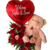Teddy bear holding a red heart balloon above red and pink roses