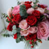 Various garden roses with touches of spiral eucalyptus arranged in a low