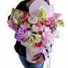 Large pastel bouquet with orchids and roses in a pink wrap