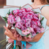 Large bouquet of pink and lavender roses with pink flowers in pastel wrapping