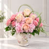Pink and peach roses arranged in a floral vase with hydrangeas