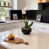 White orchid in a black pot on a kitchen island