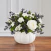 White floral arrangement in a white pumpkin-shaped vase