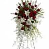 Tall standing spray of red roses and white lilies on a metal easel