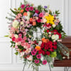 Overflowing with color and meaning, this lush wreath is a heartfelt tribute