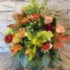 Autumn bouquet with orange and yellow flowers in a clear glass vase
