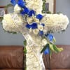 White floral funeral cross with blue and white roses and a memorial ribbon