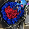 Heart-shaped bouquet of red and blue roses with a plush toy