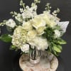 White roses and hydrangeas arranged in a silver vase