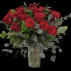 Bouquet of red roses in a clear glass vase with eucalyptus