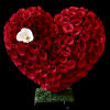 Heart-shaped arrangement of red roses with a white orchid accent