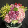 Mixed bouquet of pink roses, hydrangeas, tulips, and green orchids in a vase