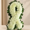 White floral ribbon arrangement with dark green leaves