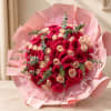 Bouquet of red and blush roses wrapped in pink paper