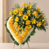 Heart-shaped yellow and white floral standing spray on an easel