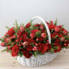 Basket of red roses and pink tulips with greenery