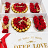 Heart-shaped rose and chocolate gift box with red roses and gold-wrapped candies