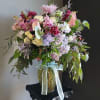 Large mixed bouquet in a glass vase with a pale ribbon