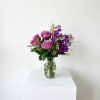 Pink and purple flower arrangement in a clear glass vase