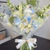 White and pale blue bouquet in a glass vase with a ribbon bow