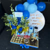 Blue balloon gift set with flowers, chocolates, cakes, and drinks in a tray