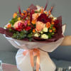 Bouquet of peach, red, and white roses with orange berries