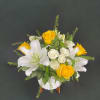 White lilies and yellow roses arranged in a white vase