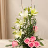 Pink roses and white lilies arranged in a black vase